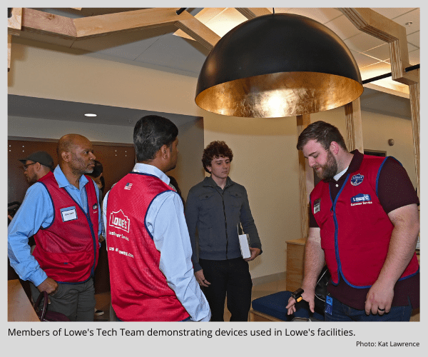 Members of Lowe's Tech Team demonstrating devices used in Lowe's facilities.